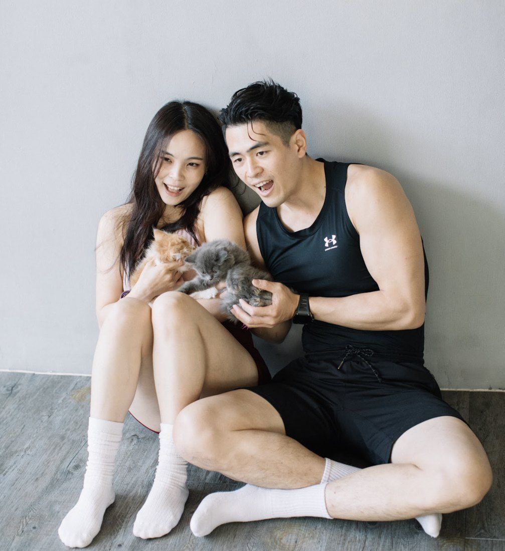 Couple playing with two fluffy kittens