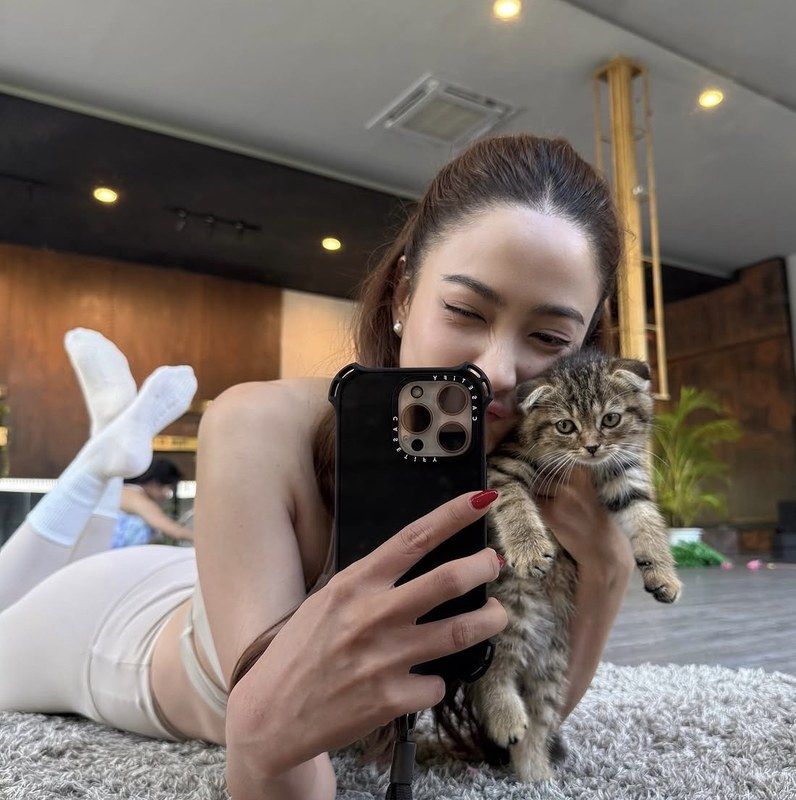 Taew Natapohn cuddling a tabby kitten at Furapy