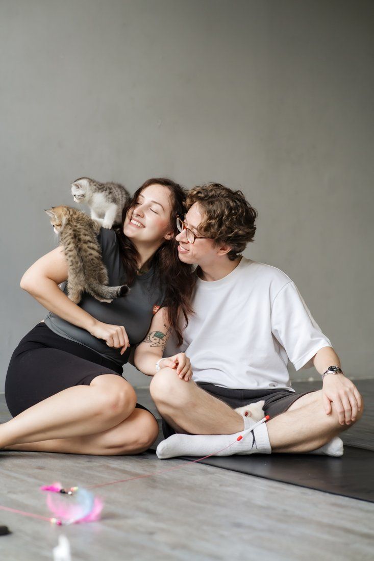Couple laughing with kittens on her shoulder