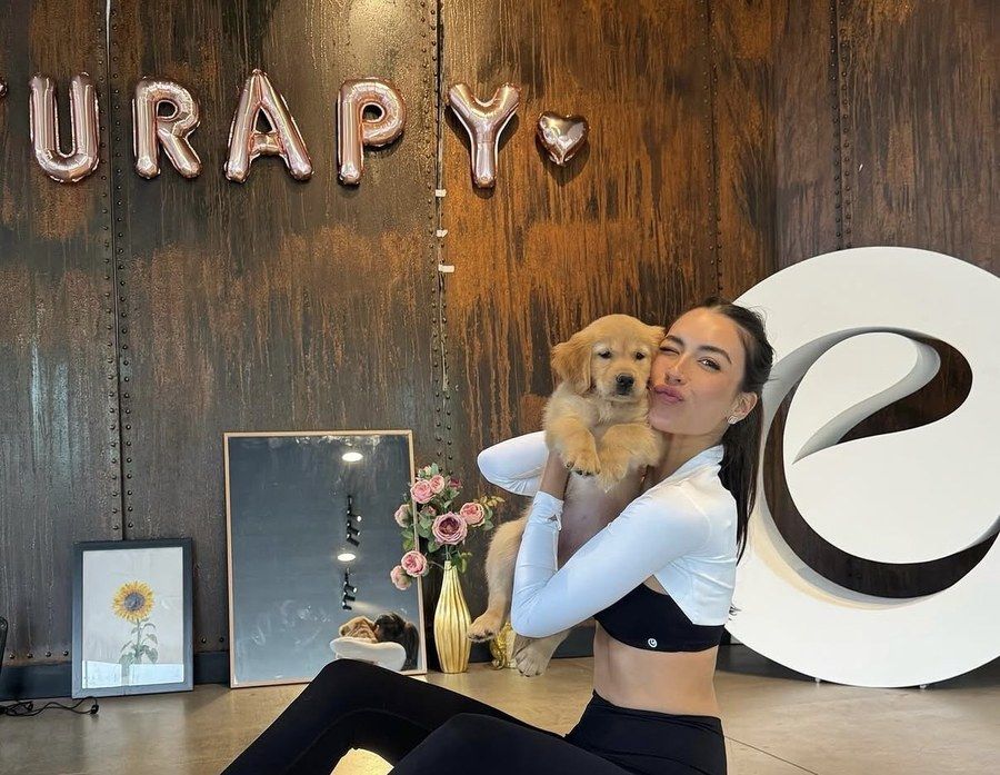 Jazzy Chewter hugging a golden retriever puppy at Furapy
