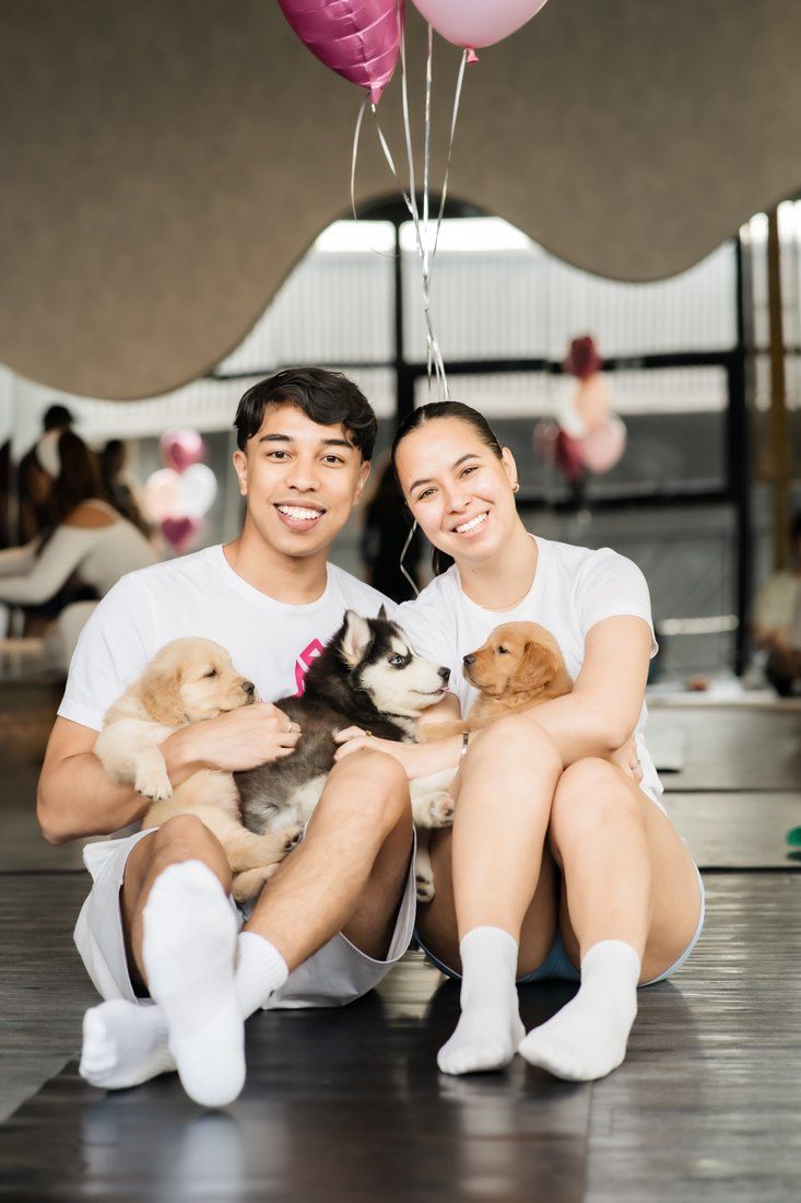 Couple with golden and husky puppies