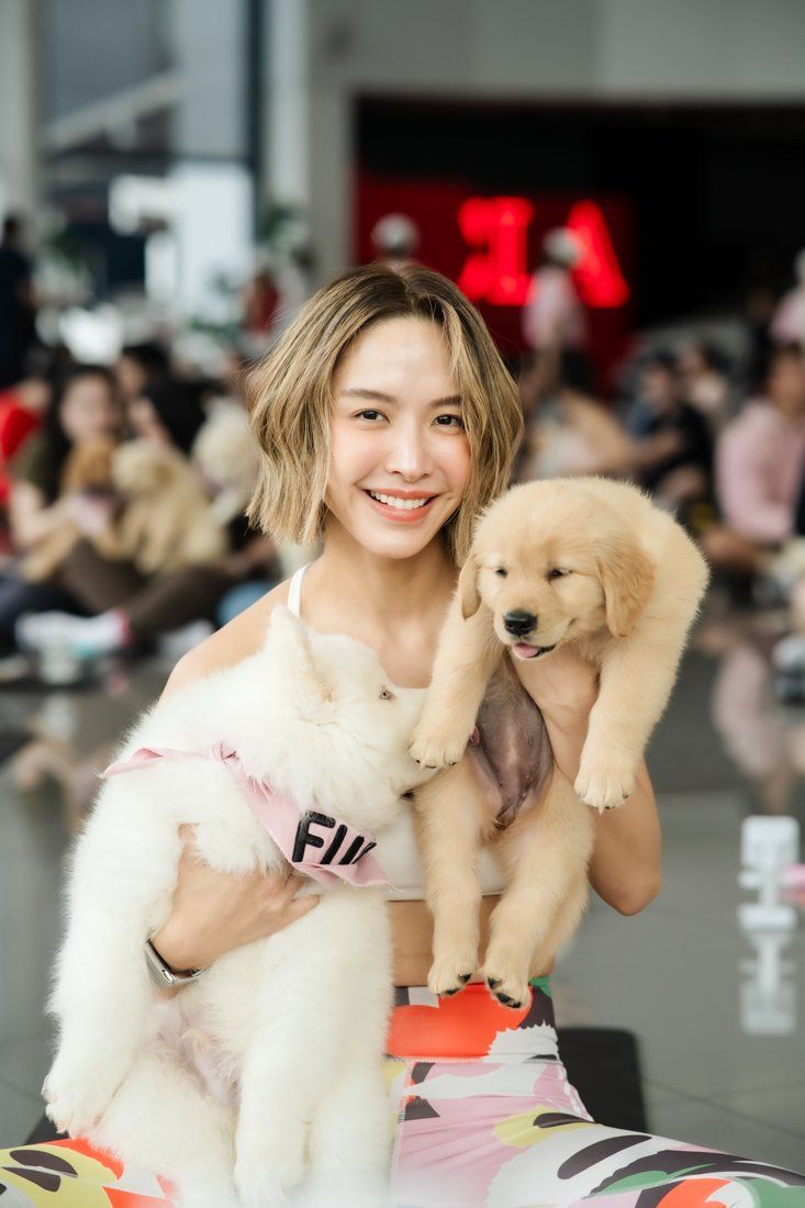 Guest holding samoyed and golden retriever puppies at the Mercedes-Benz Thonburi Phanich event