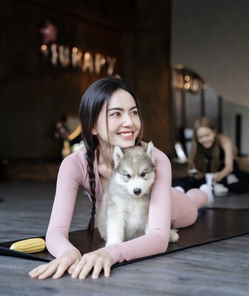Mai Davika doing puppy yoga with a husky puppy at Furapy