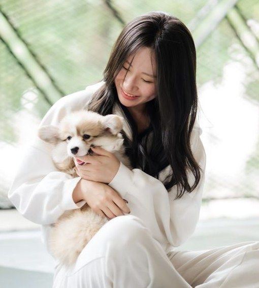 Guest in white hugging a corgi puppy