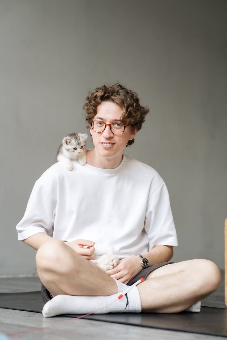 Smiling guest with a kitten on his shoulder