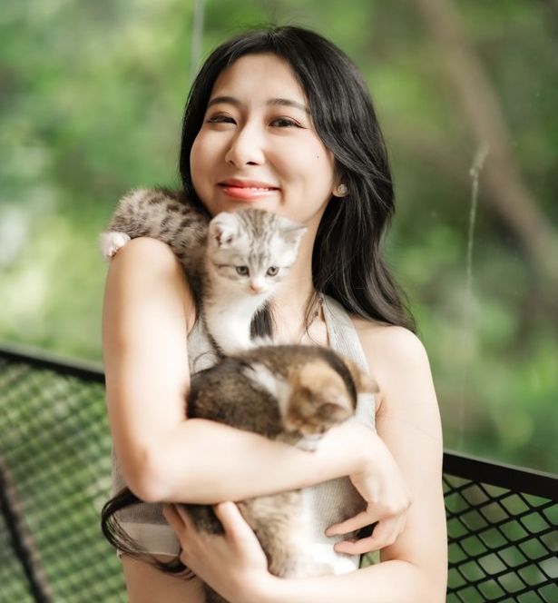 Smiling guest hugging two kittens